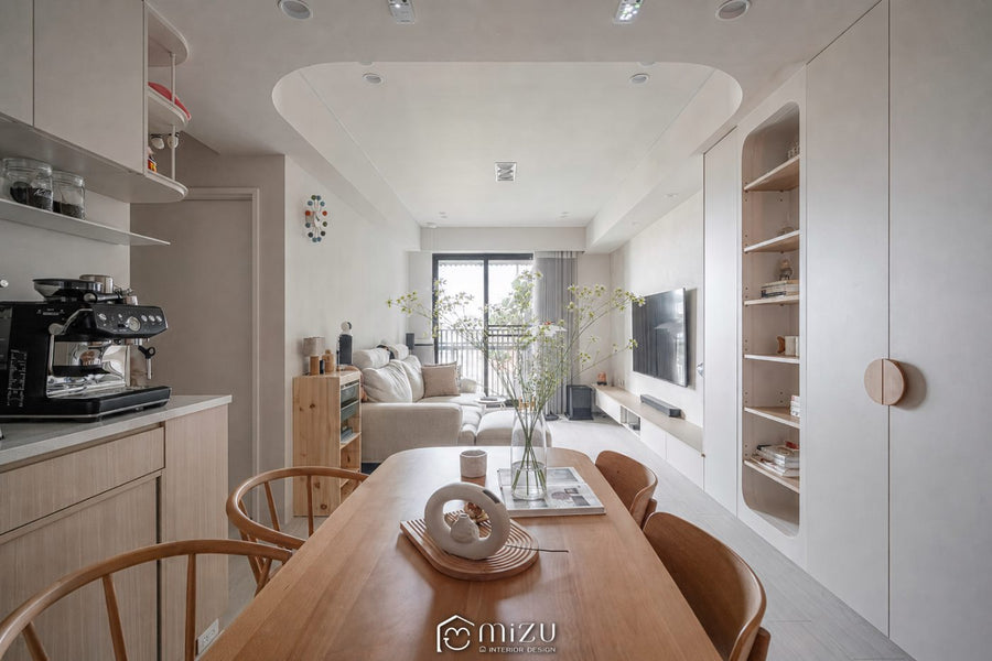 餐廳望向客廳全景，弧形天花、淺色櫃體與木質餐桌串聯開放空間 | GP7109 萊博淺橡 超耐磨木地板 | NAXHORN 犀牛地板