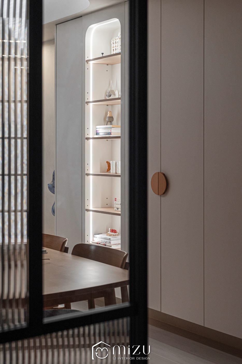 走道望向餐廳弧形玻璃展示櫃與木質餐桌 | NAXHORN 犀牛地板